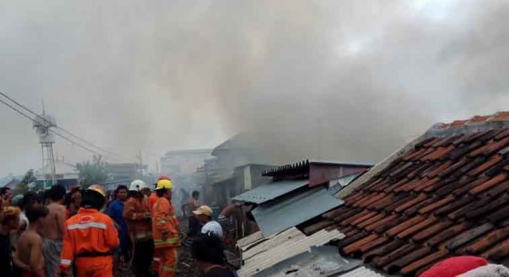 Petugas damkar memadamkam api yang membakar rumah di Jalan Kapasari DKA 3