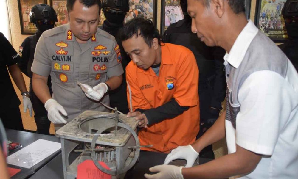 Tersangka menunjukkan tempat penyembunyian pil koplo di dlam kompor minyak