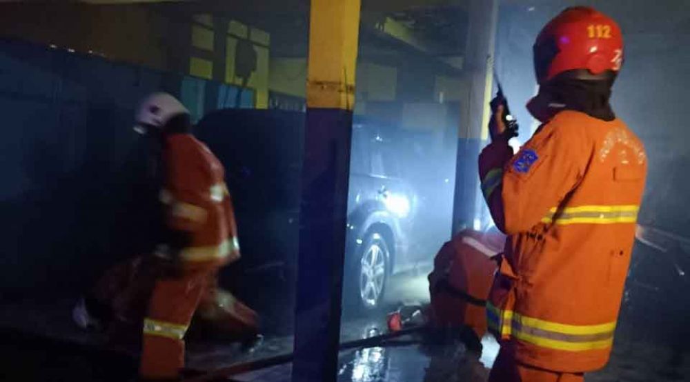 PMK Kota Surabaya memadamkan api yang membakar bengkel mobil di Petemon
