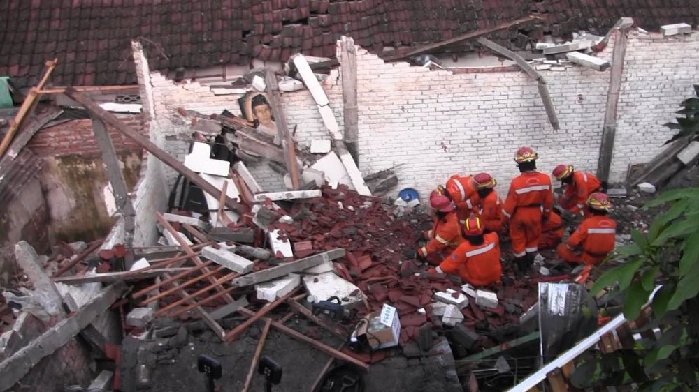 Petugas mencari keberadaan korban yang tertimpa reruntuhan tembok