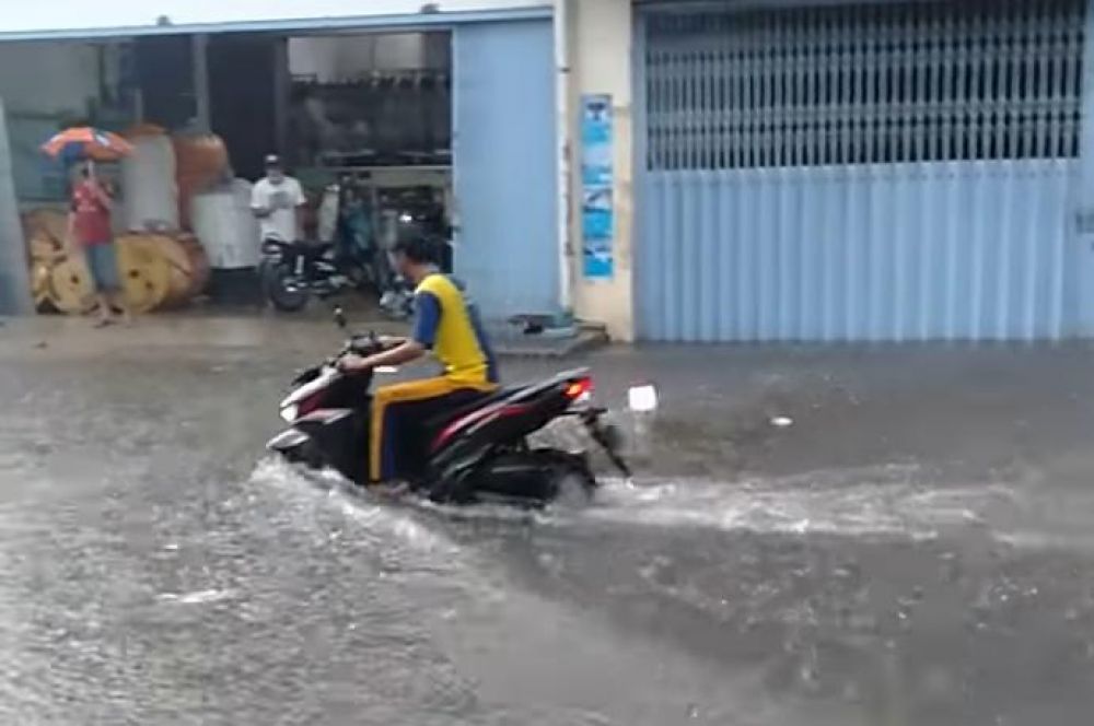 Seorang pengendara motor melintas di Pucang Anom Surabaya yang terendam banjir
