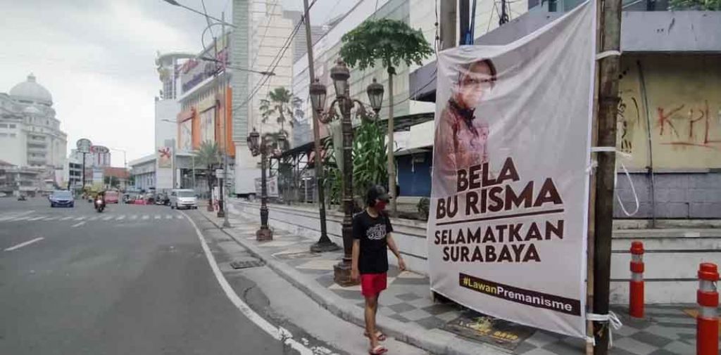 Warga melintas di depan baliho 