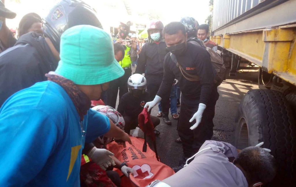 Petugas mengevakuasi korban dari kolong trailer (Foto istimewa)