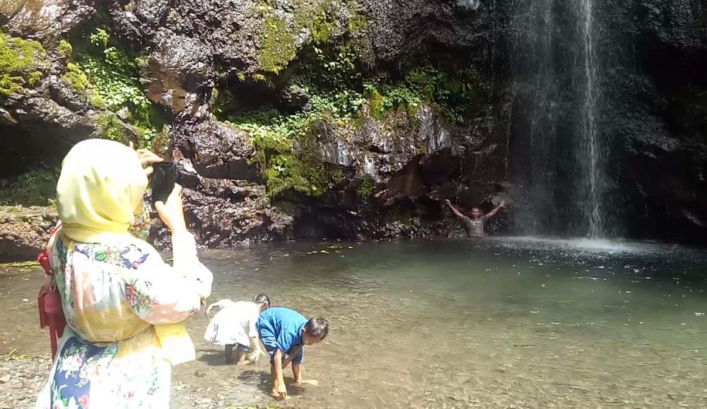 Pengunjung menikmati wisata Air Terjun Kakek Bodo, Pasuruan