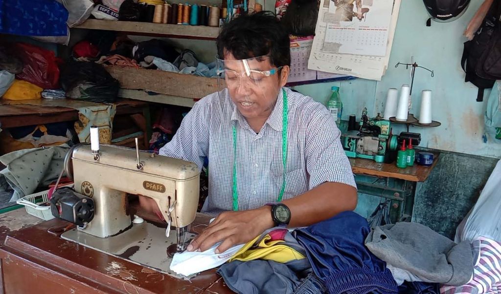 Yasir saat menjahit pakaian pesanan pelanggan