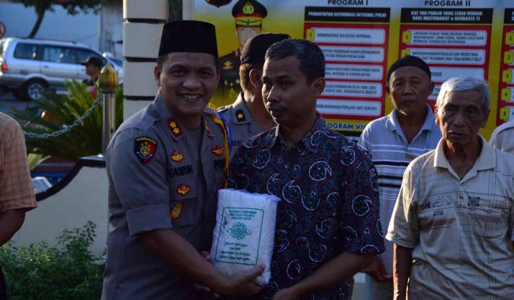 Kapolres Madiun Kota, AKBP Nasrun Pasaribu membagikan paket zakat fitrah kepada salah satu warga