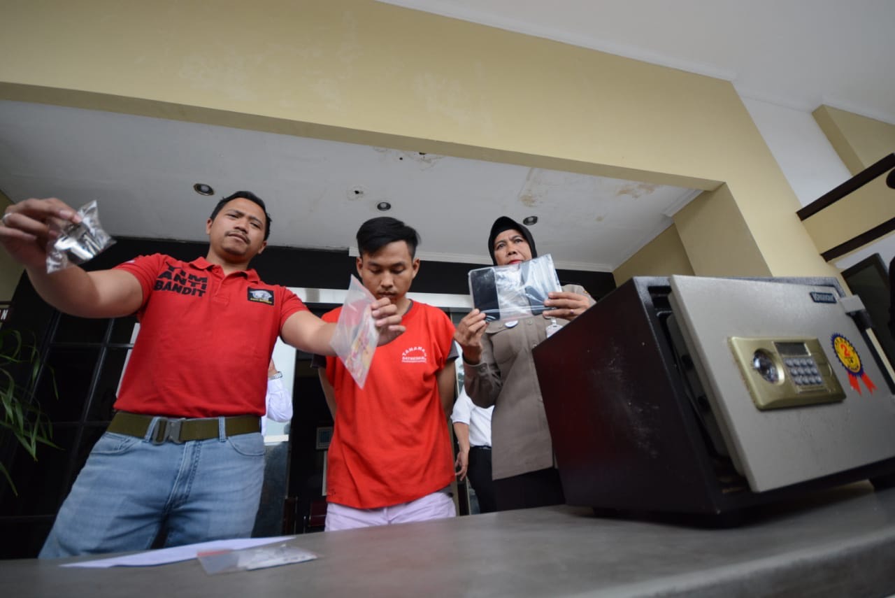 Iptu Bima Sakti menunjukkan barang bukti dan tersangka pembobolan brankas.
