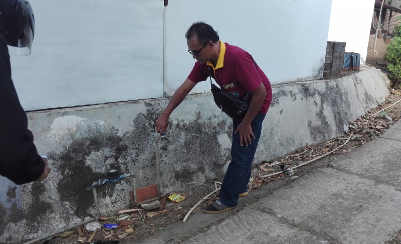 Warga menunjukkan air PDAM yang macet di krannya.