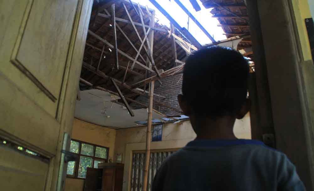 Salah satu siswa melihat atap kelasnya yang ambruk