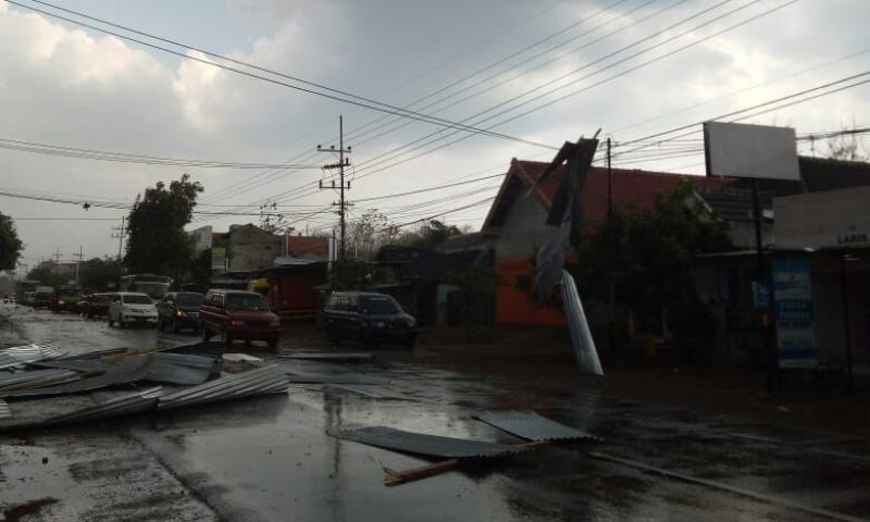 Hujan disertai angin kencang menerjang Jalan Raya Madiun-Ponorogo, sehingga seng bangunan pun beterbangan, Jumat (21/9/2018).