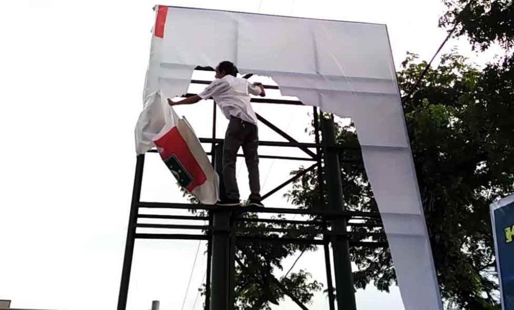 Anggota Bawaslu Pasuruan mencopot salah satu reklame APK