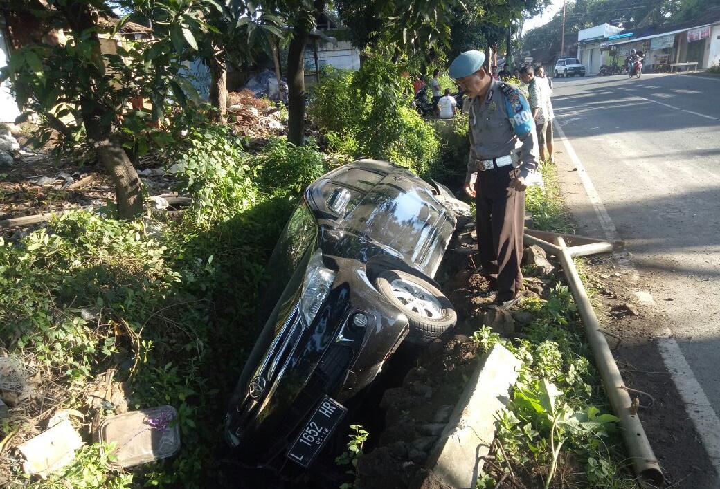 Sebuah mobil Avanza nyungsep di parit