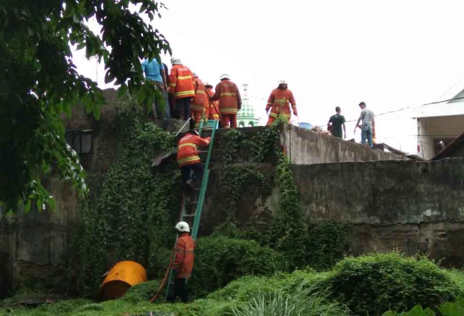 Petugas PMK melakukan pembasahan di kamar lantai 2 yang terbakar