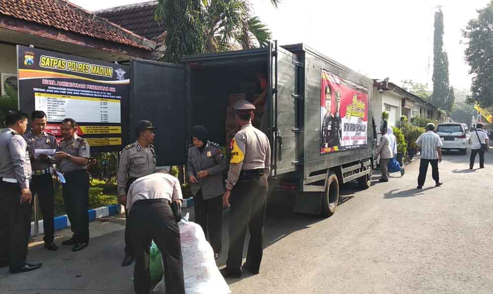 Petugas polisi menaikan bantuan ke atas truk untuk dibawa ke Lanud Iswahjudi