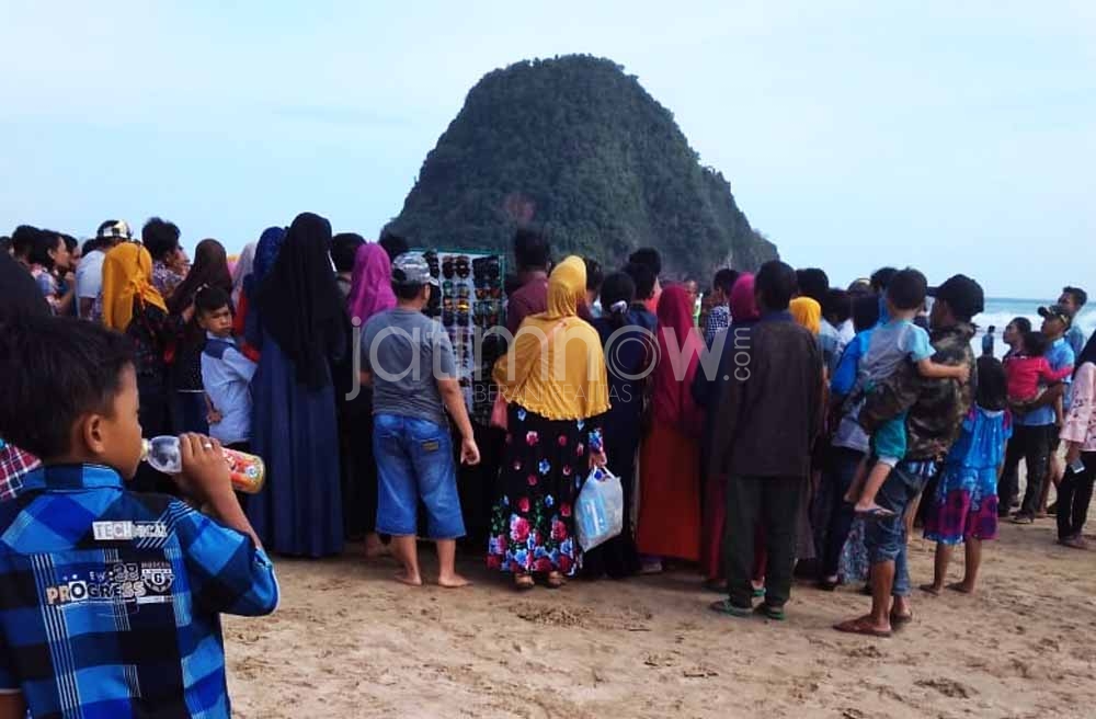 Pengunjung berkerumun melihat proses evakuasi dua wisatawan yang terseret ombak