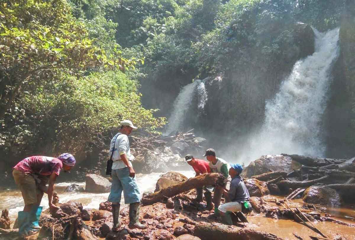 Warga membersihkan lokasi penemuan air terjun baru di lereng Gunung Raung.