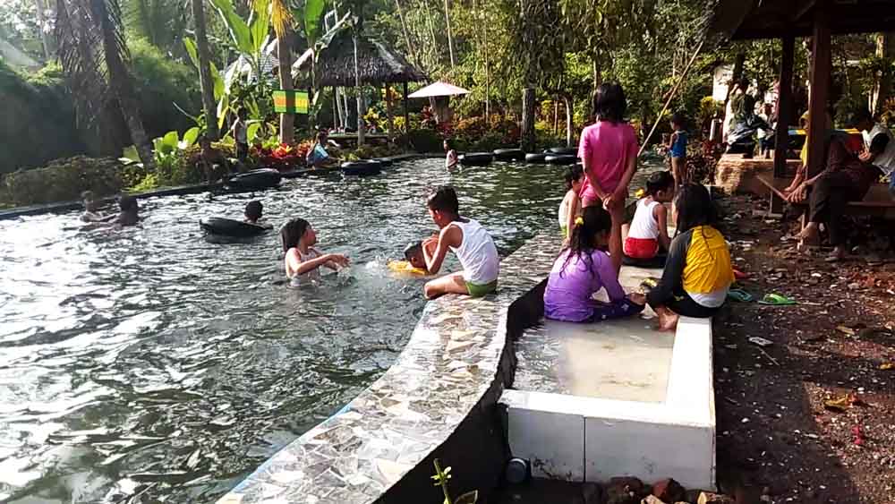 Pengunjung menikmati pemandian air pegununggan di Wisata Batu Hitam