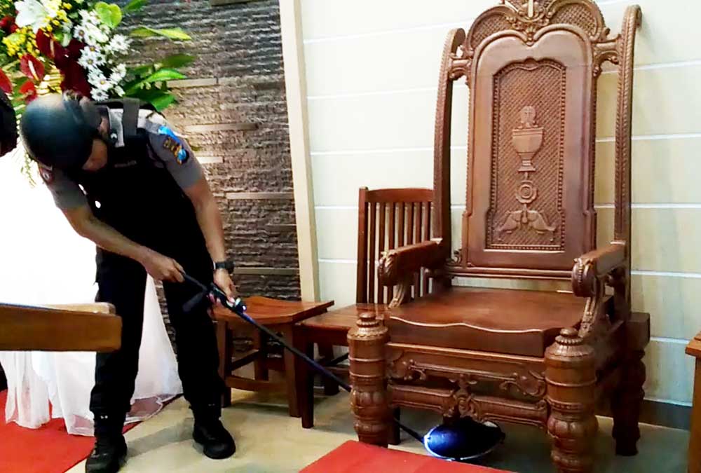 Anggota polis memeriksa setiap sudut di gereja