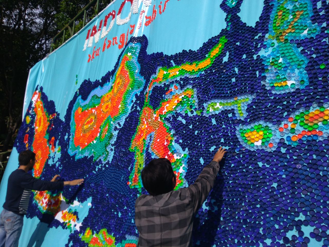 Mahasiswa Ubaya saat membuat peta Indonesia dari botol bekas.