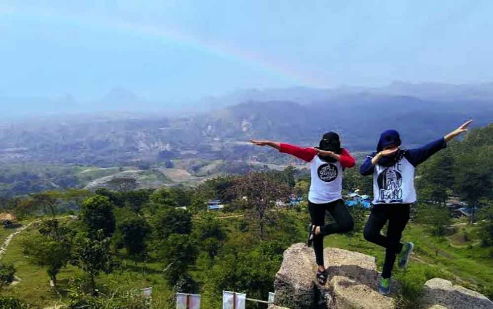 Dua wisatawan sedang berfoto di Bukit Cinta