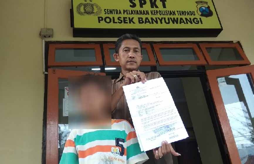 Mukti bersama anaknya saat melapor ke Polsek Banyuwangi