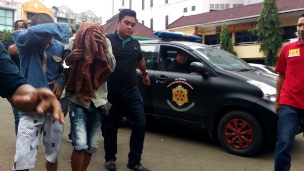 MF (wajah ditutup) dan Suhendra saat digelandang di Mapolres Pelabuhan Tanjung Perak Surabaya. 