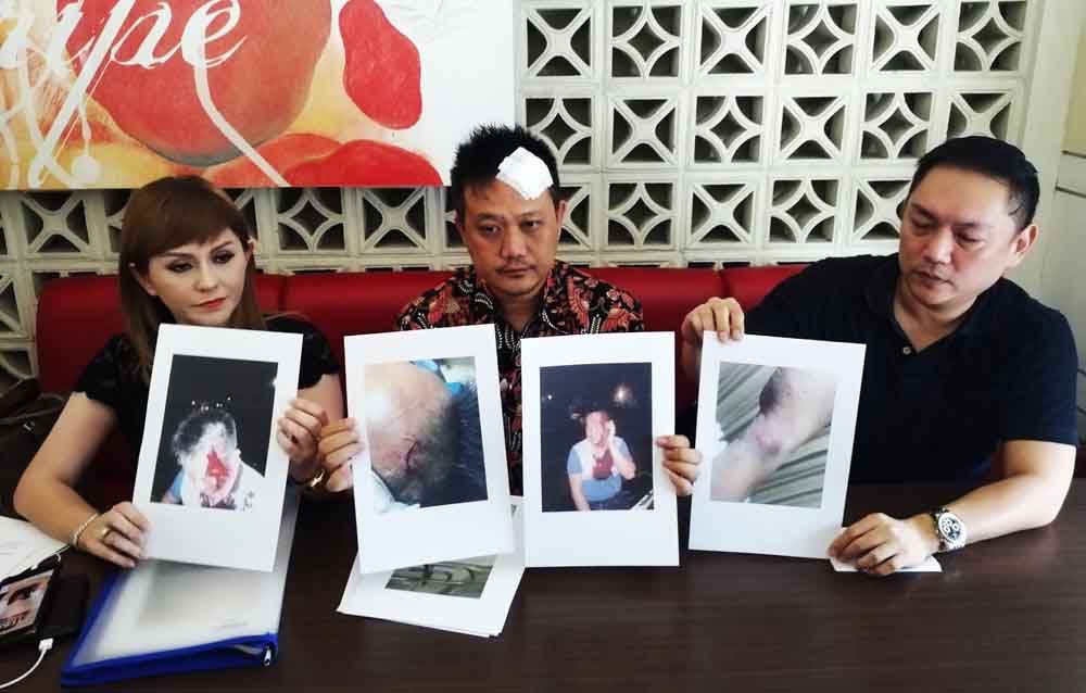 Korban (tengah) menunjukkan bukti penganiayaan