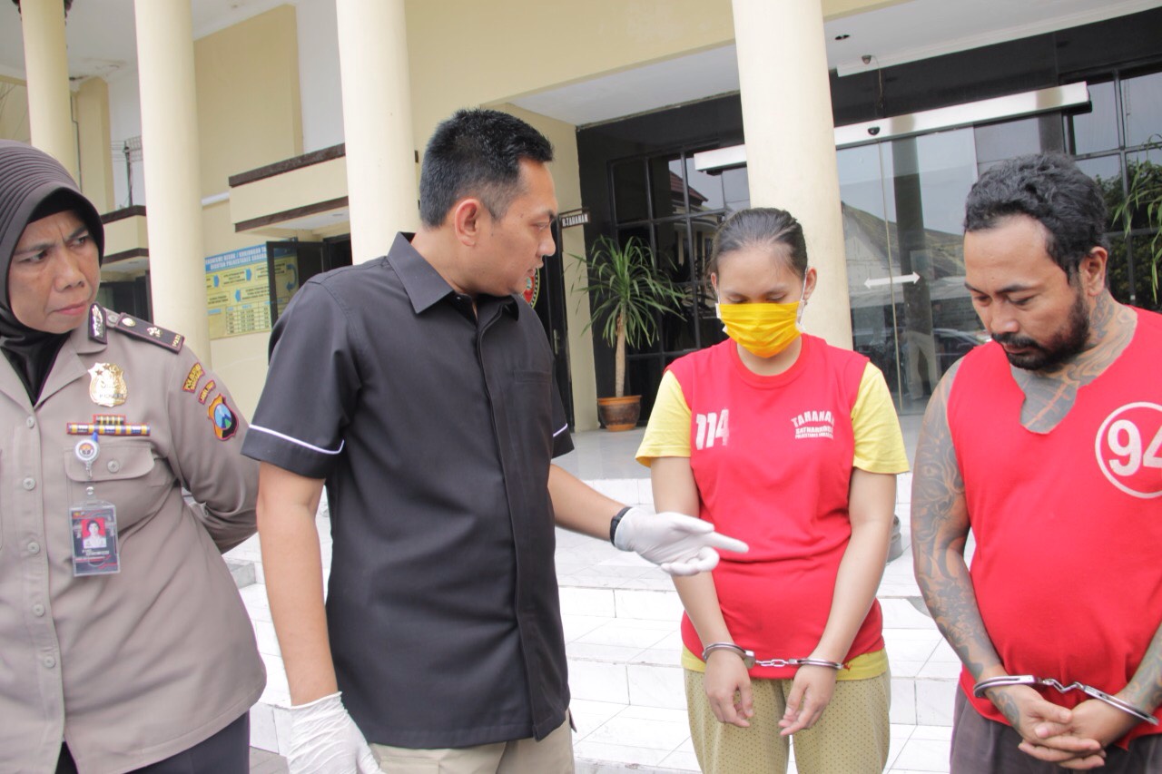 Irawati (bermasker kuning) diamankan di Mapolrestabes Surabaya.

