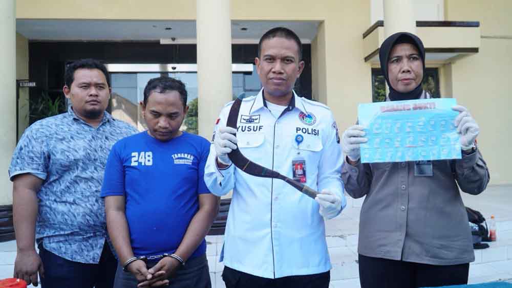 Tersangka (baju biru) saat berada di Mapolrestabes Surabaya