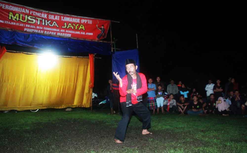 Budayawan Miftahul Rahman memperagakan sejumlah jurus silat Tjimande, pada Silaturahim Tjimande se Jember, di lapangan Desa Tisnogambar  Minggu, (24/3/2019).