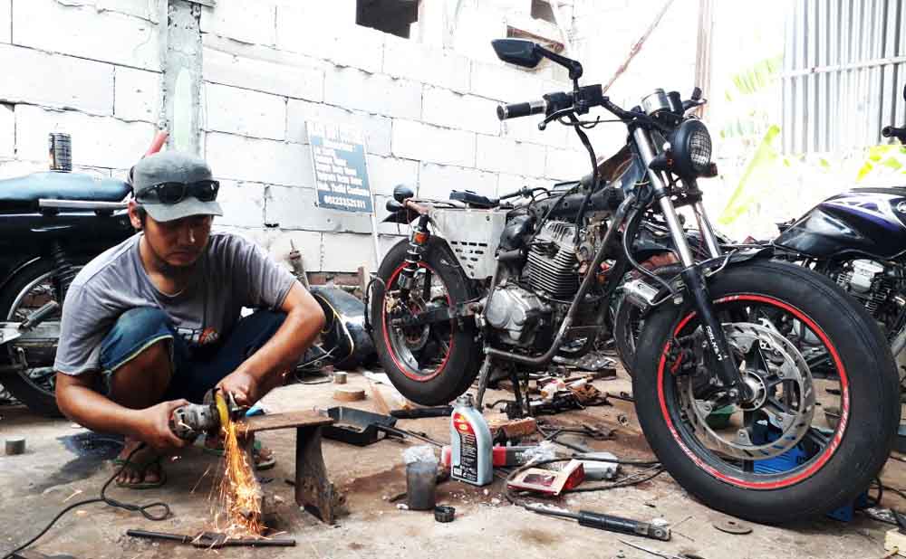 Yudi saat bekerja memodifikasi motor di bengkelnya