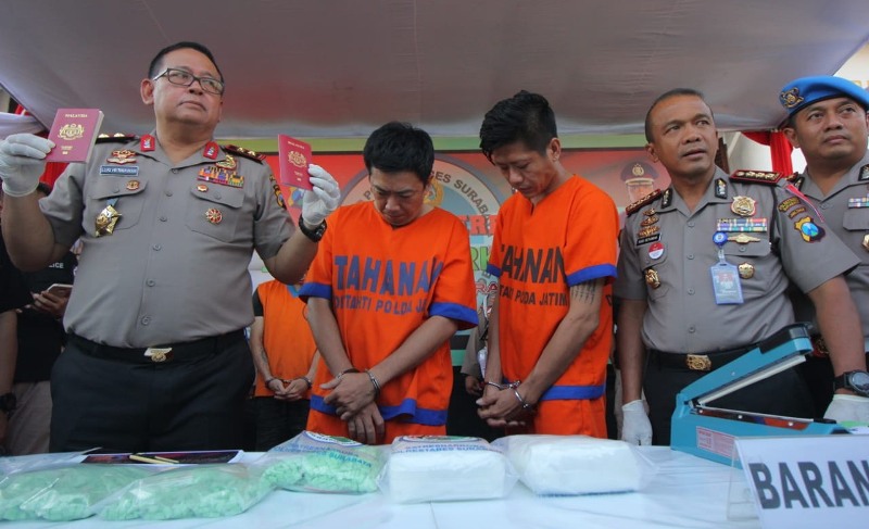 Kapolda Jatim Irjen Pol Luki Hermawan menunjukkan paspor kedua WN Malaysia yang menjadi kurir narkoba.