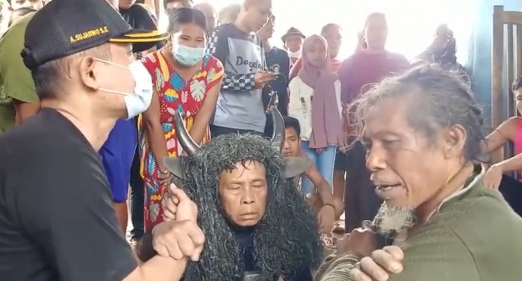 Kades Anton Sujarwo (memakai topi) di hadapan dua warga yang kerasukan roh leluhur.