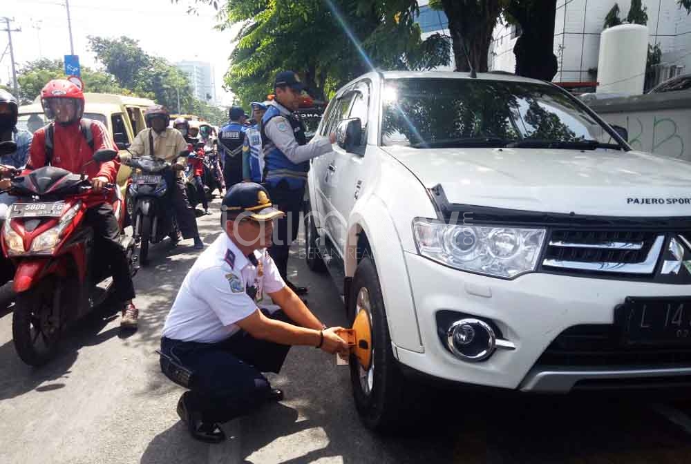 Petugas menggembok mobil parkir sembarangan di kawasan RSU dr Soetomo Surabaya