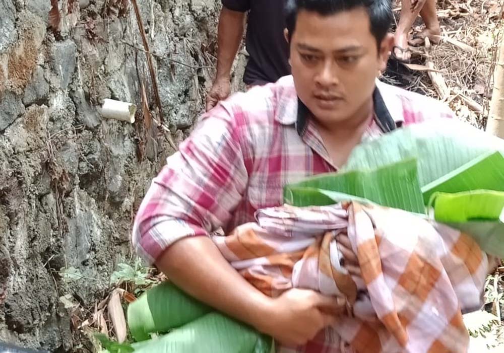 Polisi saat evakuasi mayat bayi dari sungai (Dok Polsek Genteng)