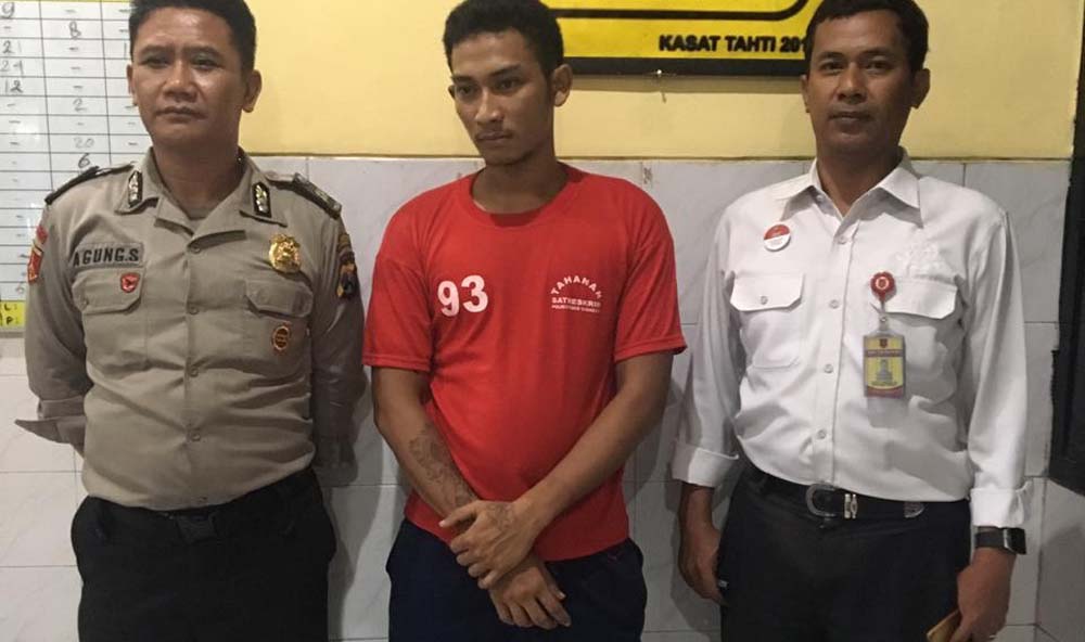 Teddy (tengah) saat hendak dijebloskan ke sel tahanan polisi.
