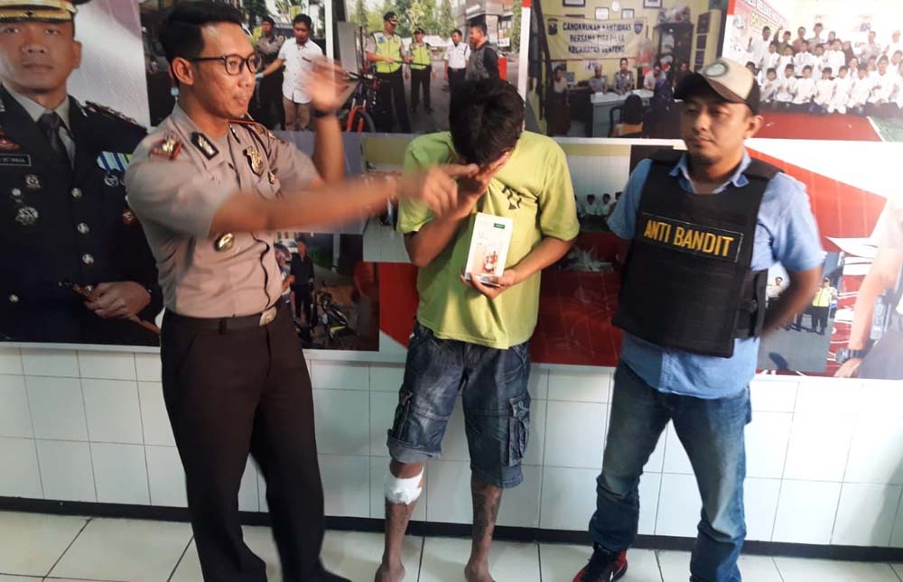 Martin Johan Robot (tengah) diamankan di Mapolsek Genteng.