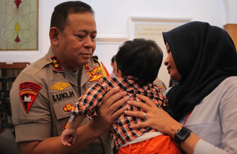 Kapolda Jatim Irjen Pol Luki Hermawan saat hendak menggendong balita korban perdagangan online, Kamis (11/10/2018).