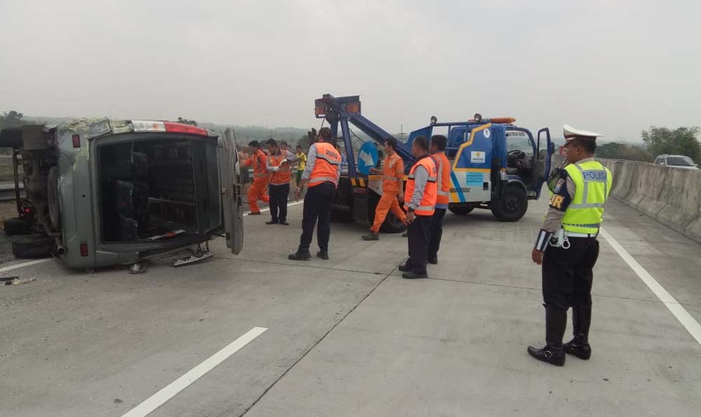 Petugas patroli tol saat melakukan evakuasi kendaraan Elf yang terguling./ Foto: Istimewa.