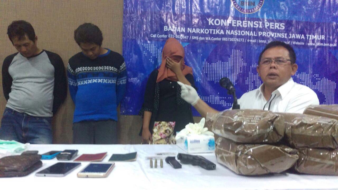 Wahyudi (tengah) dan istrinya Ayuk Selsi Handayani (berjilbab) saat diamankan di Kantor BNNP Jatim