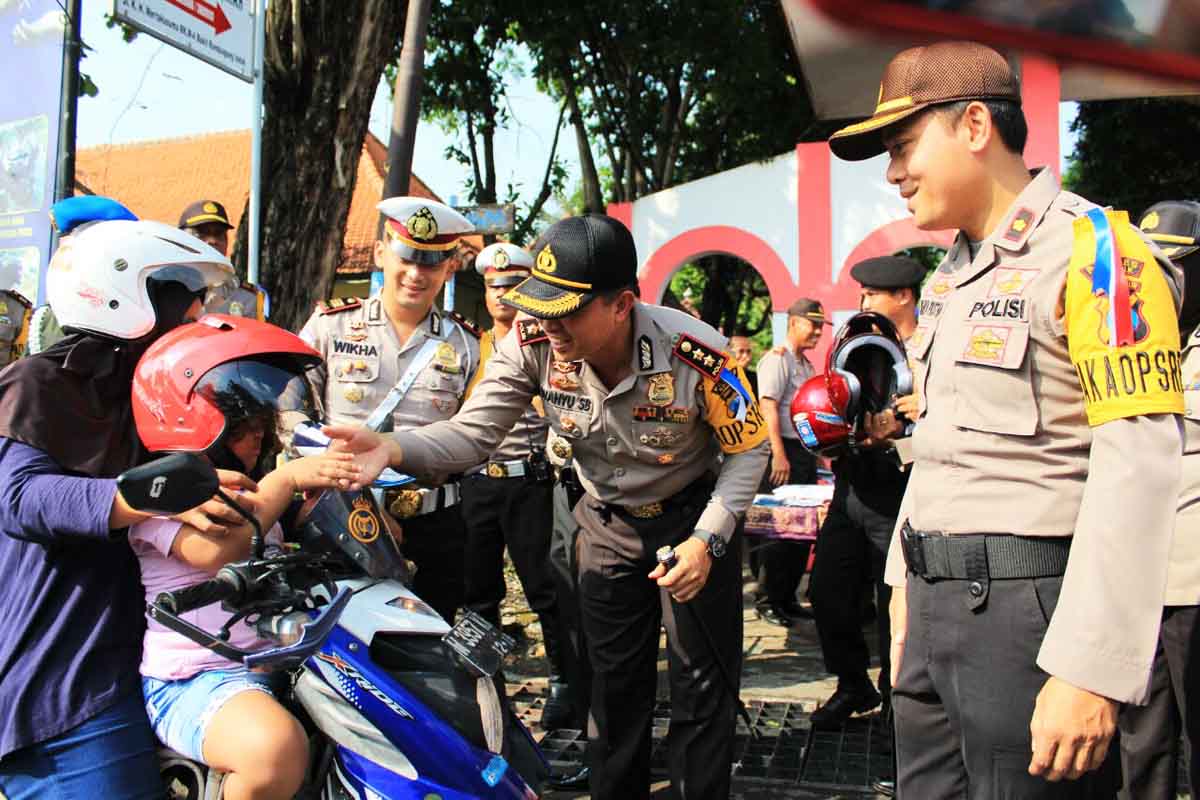Kapolres Geresik AKBP Wahyu S Bintoro mebagi-bagikan helm kepada pengendara.