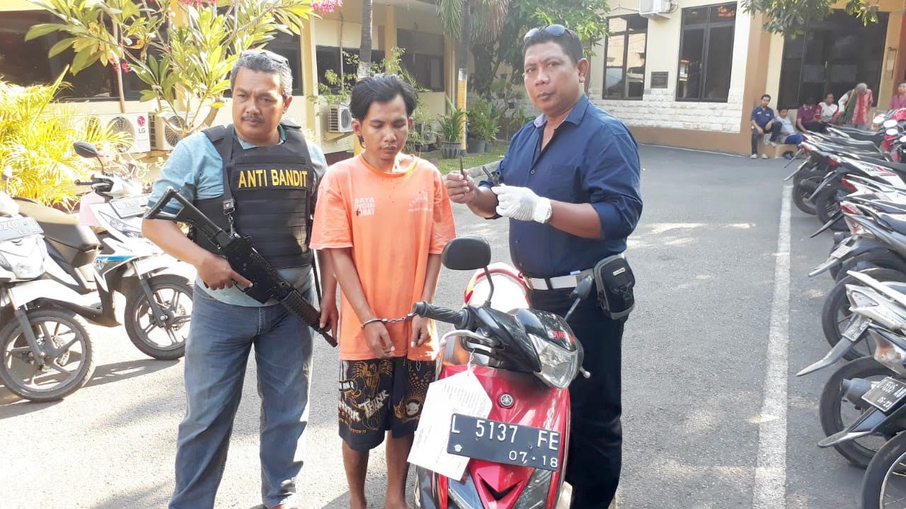 Rizki (tengah) bersama motor yang dicurinya di Mapolsek Gubeng Surabaya.