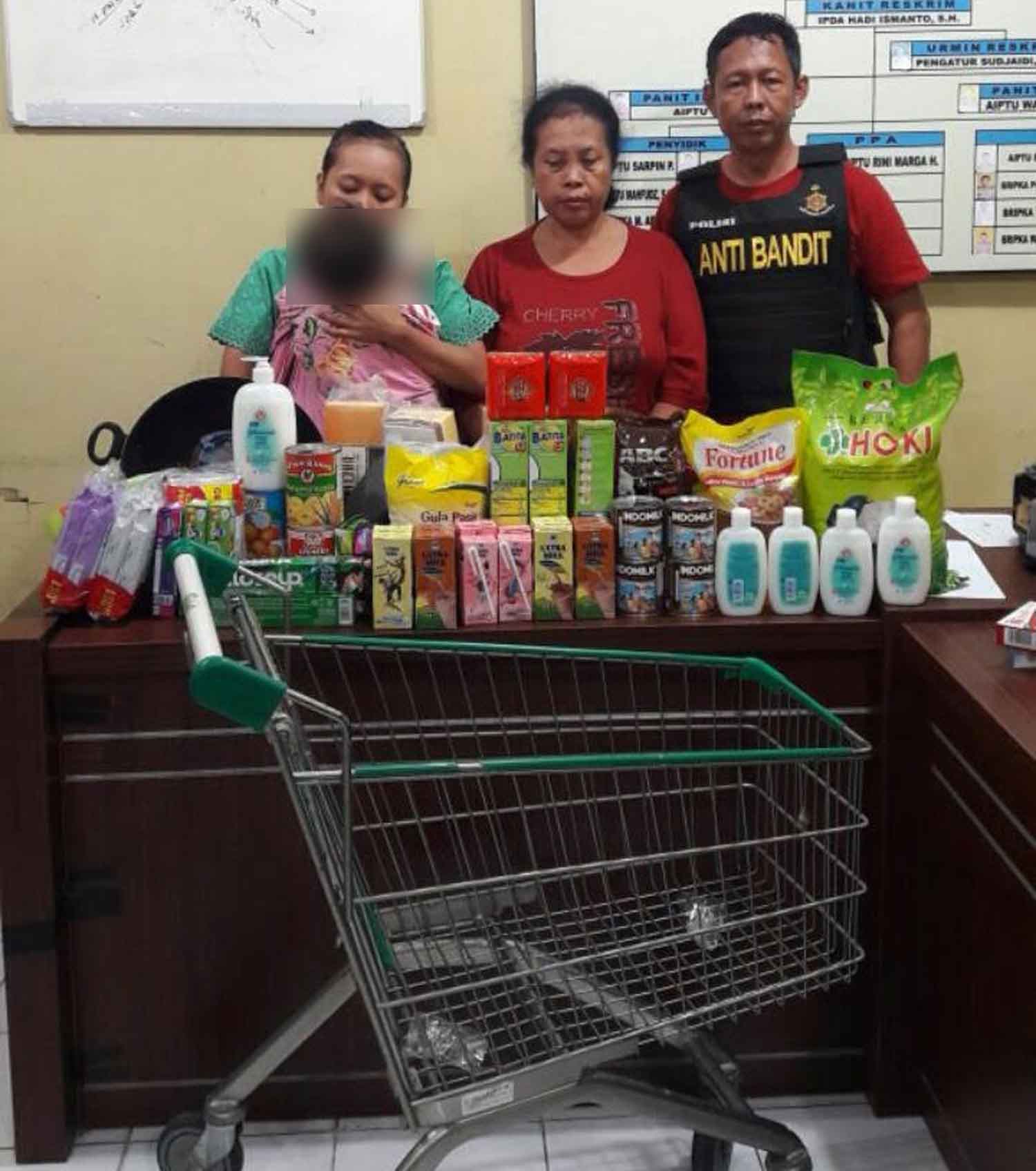 Liana dan Merry bersama barang hasil curian  di Mapolsek Lakarsantri Surabaya. 