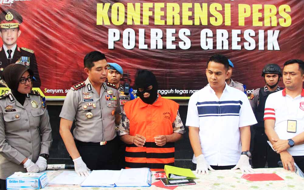 Tersangka Kepala Desa Segoromadu saat diamankan di Mapolres Gresik