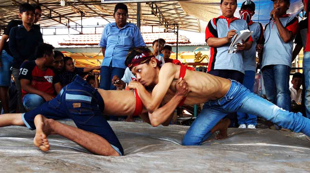 Pegulat okol sedang bertanding untuk merobohkan lawannya