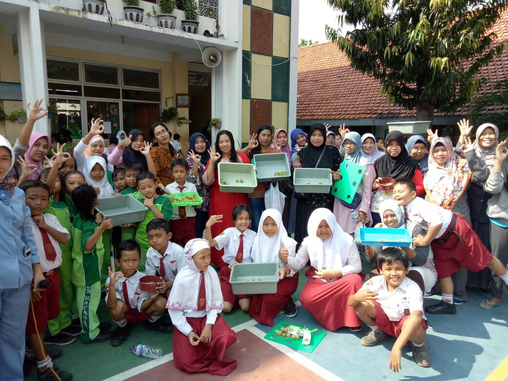 Para pelajar dan wali murid saat melakukan semai benih sawi di sekolah.