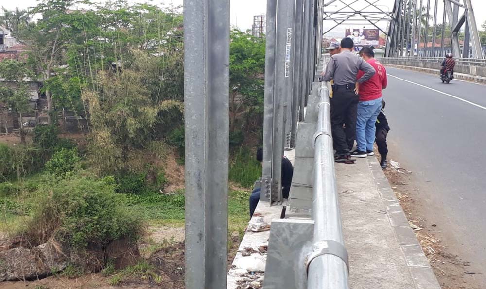 SR (kaos hitam) saat di sisi jembatan dan petugas polisi hendak melakukan evakuasi.