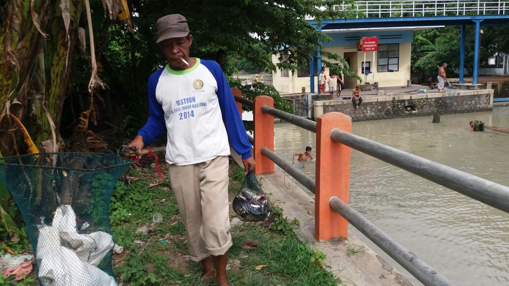 Seorang warga dengan hasil ikan tangkapannya