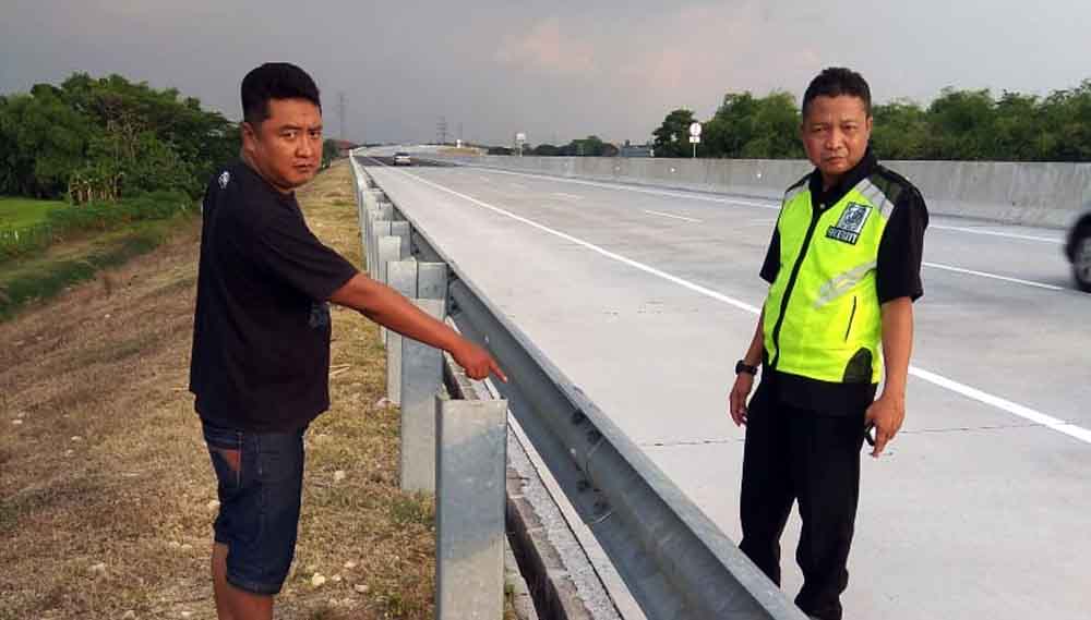 Petugas jalan tol menunjukkan jenis pagar pembatas yang dicuri