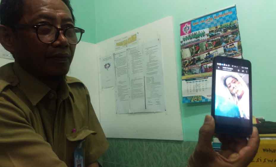 Wakil Kepala Sekolah SMK Rajasa menunjukkan foto Tifani semasa dirawat di rumah sakit